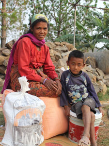 Mutter und Sohn mit Hilfsgütern. (Foto: Diakonie Katastrophenhilfe)