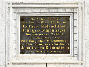 Auf einem Schild sind die Namen der Reformatoren festgehalten, die sich in Torgau trafen. (Foto: epd-Bild/Jens Schulze)