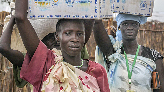 Frauen im Flchtlingslager von Bentiu/Sdsudan tragen Lebensmittelrationen zu ihren Zelten