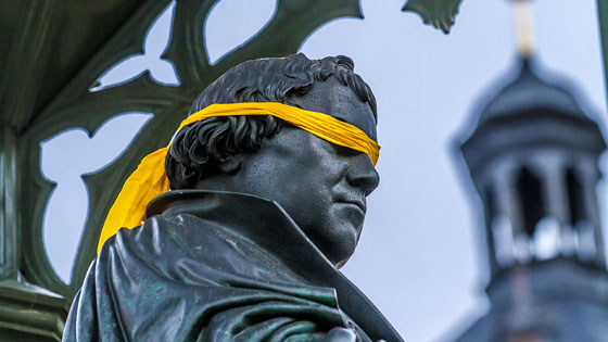 Denkmal von Martin Luther auf dem Wittenberger Marktplatz mit Augenbinde - Kunstaktion als Protest gegen die Judenfeindlichkeit des reformators
