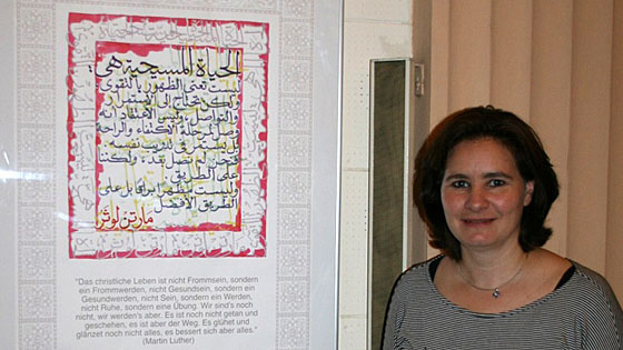 Pfarrerin Nadja el-Karsheh vor einer Kalligraphie