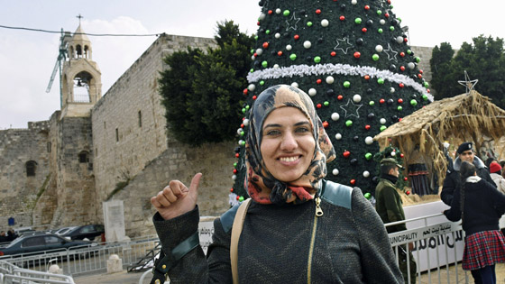 Die Palaestinenserin Narjis Dagamin (28) am Weihnachtsbaum vor der Geburtskirche Bethlehem