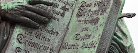 Ausschnitt des Denkmals des Reformators Martin Luther mit der von ihm ins Deutsche übersetzten Bibel in der Hand auf dem Marktplatz in der Lutherstadt Wittenberg. (Foto: epd-bild / Steffen Schellhorn)