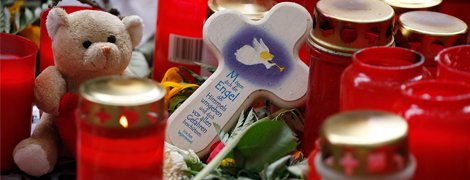 Kerzen, ein Teddybr und ein Kreuz mit Engel erinnern an die Opfer der Loveparade (Foto: epd-bild / Jrn Neumann)