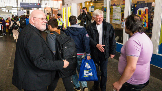 Kardinal Marx und Landesbischof Bedford-Strohm begrüßen Flüchtlinge in München.